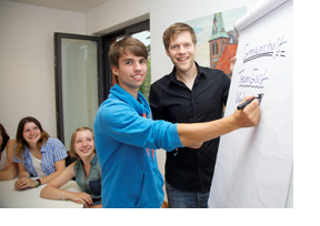 Studierende sitzen zusammen und schreiben etwas an ein Flipchart. (Foto: Sonja Brüggemann)
