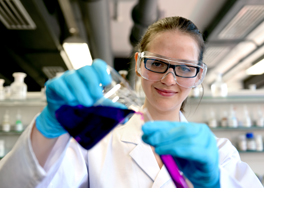 Eine junge Frau füllt eine chemische Flüssigkeit in ein Reagenzglas. (Foto: Katharina Kemme)