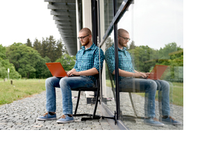 Studierender sitzt mit seinem Laptop im Freien. (Foto: Katharina Kemme)