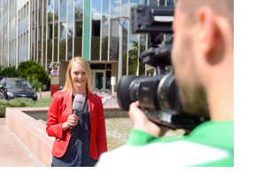 Eine Moderatorin steht mit einem Mikro in der Hand vor der Kamera. (Foto: Martin Rehm)