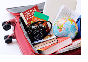 In einem offenen Koffer liegen Bücher, eine Kamera und ein Globus. (Foto: Julien Fertl)